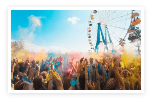 A crowd of people with colored powder on their hands.