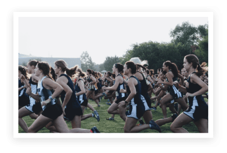 A group of women running in the grass.