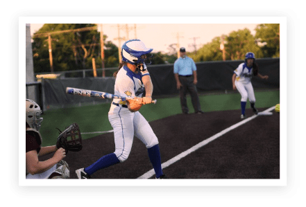 A woman swinging a baseball bat at a ball