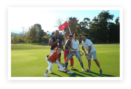 A group of people standing on top of a green field.