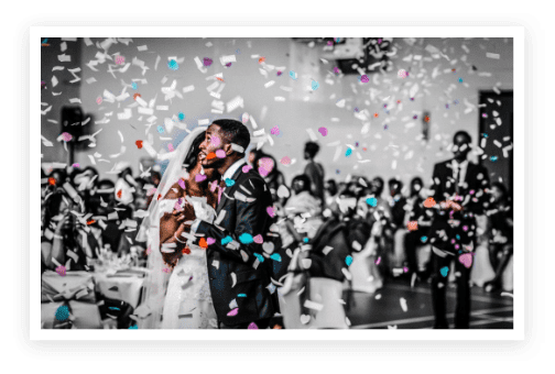 A couple kissing in front of a crowd.