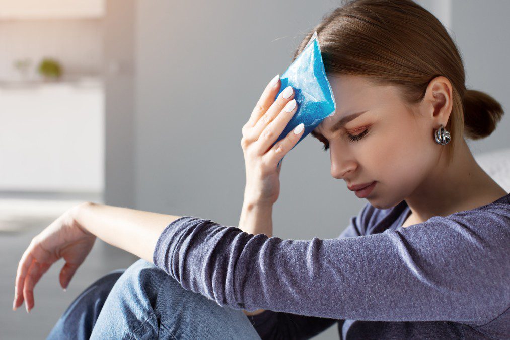 A woman holding her head with one hand and another on the other.